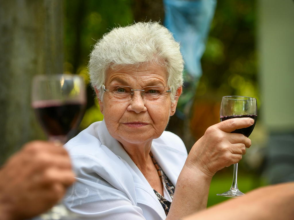 Happy Senior Woman Talking With A Friend In A Sunny Outdoor Garden — senior care guide